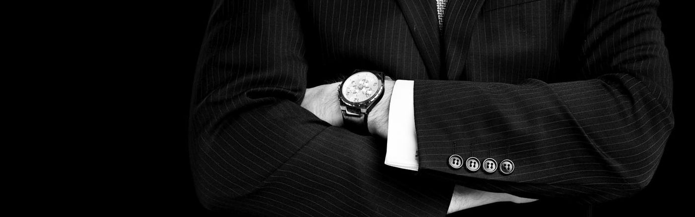 Arms folded in a suit with Pre-Owned Watch on wrist